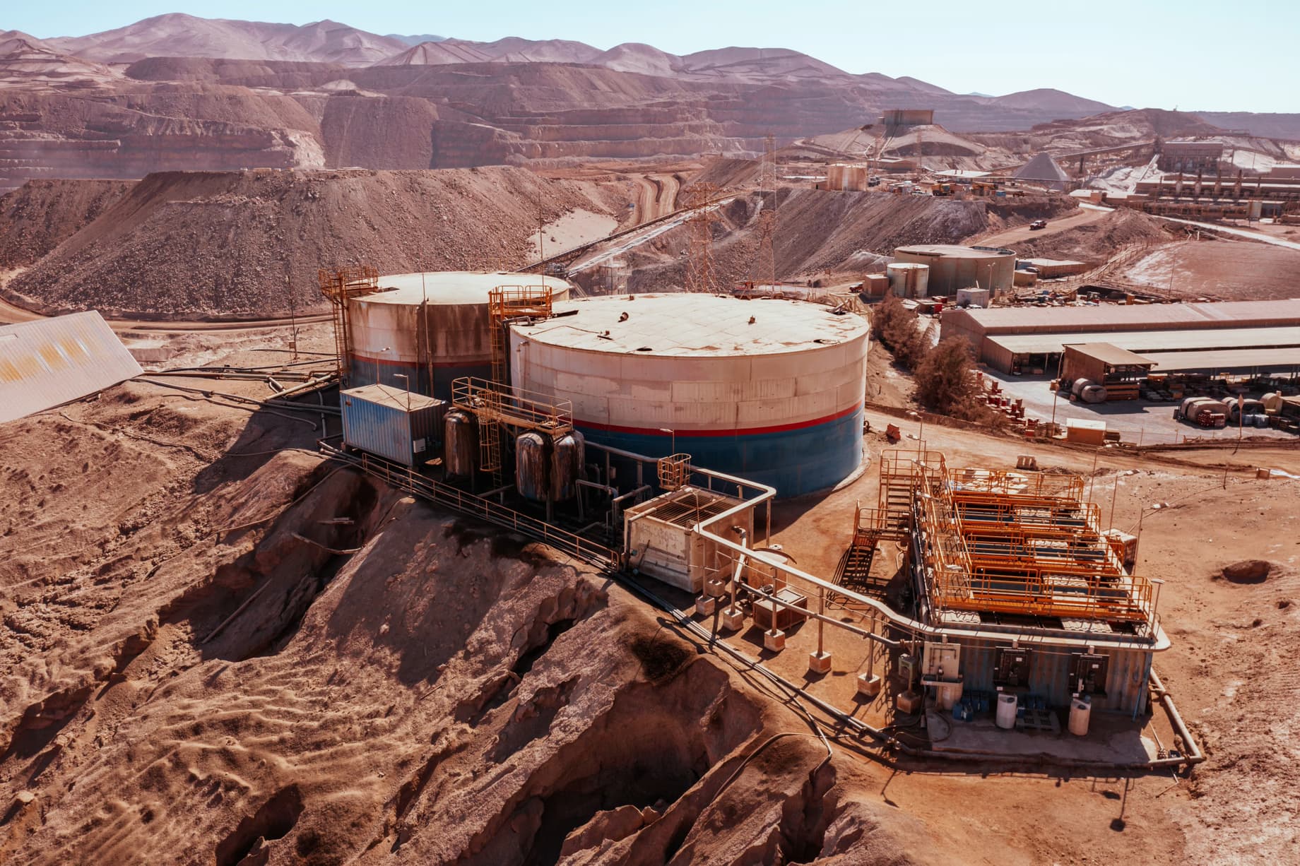 Mining water treatment system in Chile's Atacama Desert featuring reverse osmosis and industrial storage tanks, representing the environmental management infrastructure required at large copper mining operations in Latin America