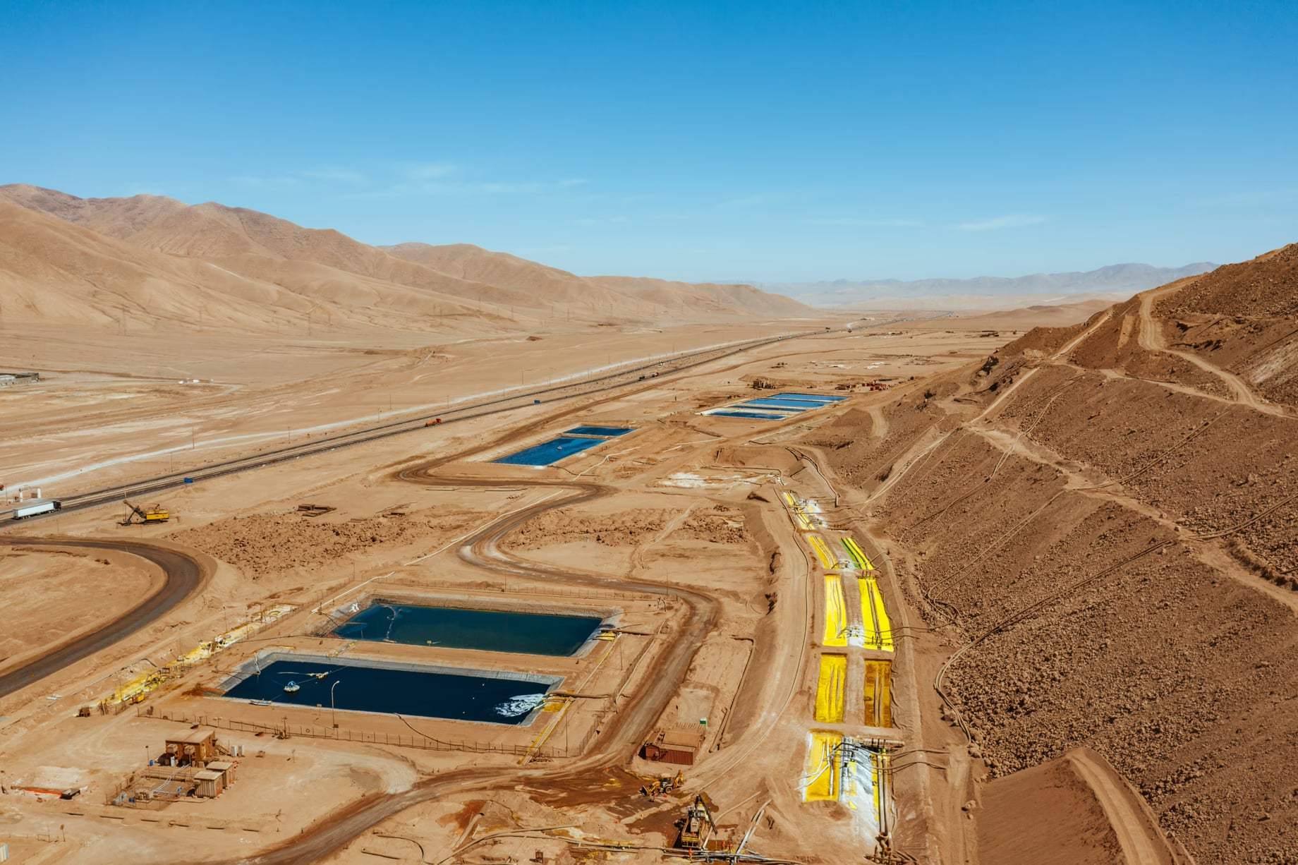 Copper leaching heaps and acid extraction ponds in Chile's Atacama Desert, illustrating the scale of Latin American mining infrastructure and the growing industry push toward sustainable, electrified mining practices