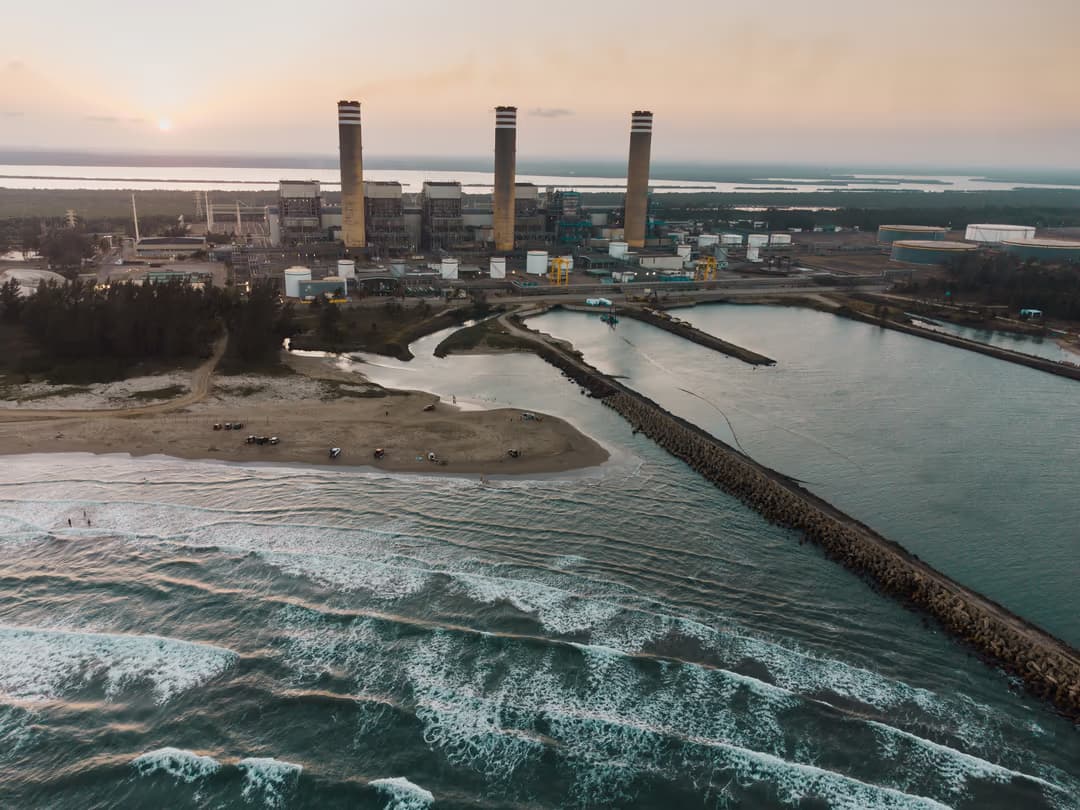 Thermal power station on the shore of a beach in Tuxpan, Veracruz, Mexico, representing the conventional fossil-fuel generation infrastructure that Mexico's 2026-2030 energy plan aims to complement with renewables and battery storage, reducing the grid's dependence on natural gas from 79 to 62 percent