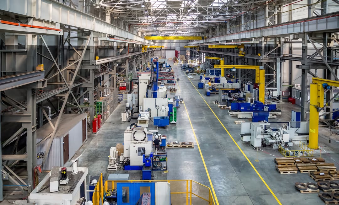 Industrial facility with an integrated on-site energy system combining battery storage, solar generation, and EV charging infrastructure — illustrating how coordinated energy assets managed by an intelligent EMS can reduce demand charges and create grid services revenue opportunities for commercial and industrial operators